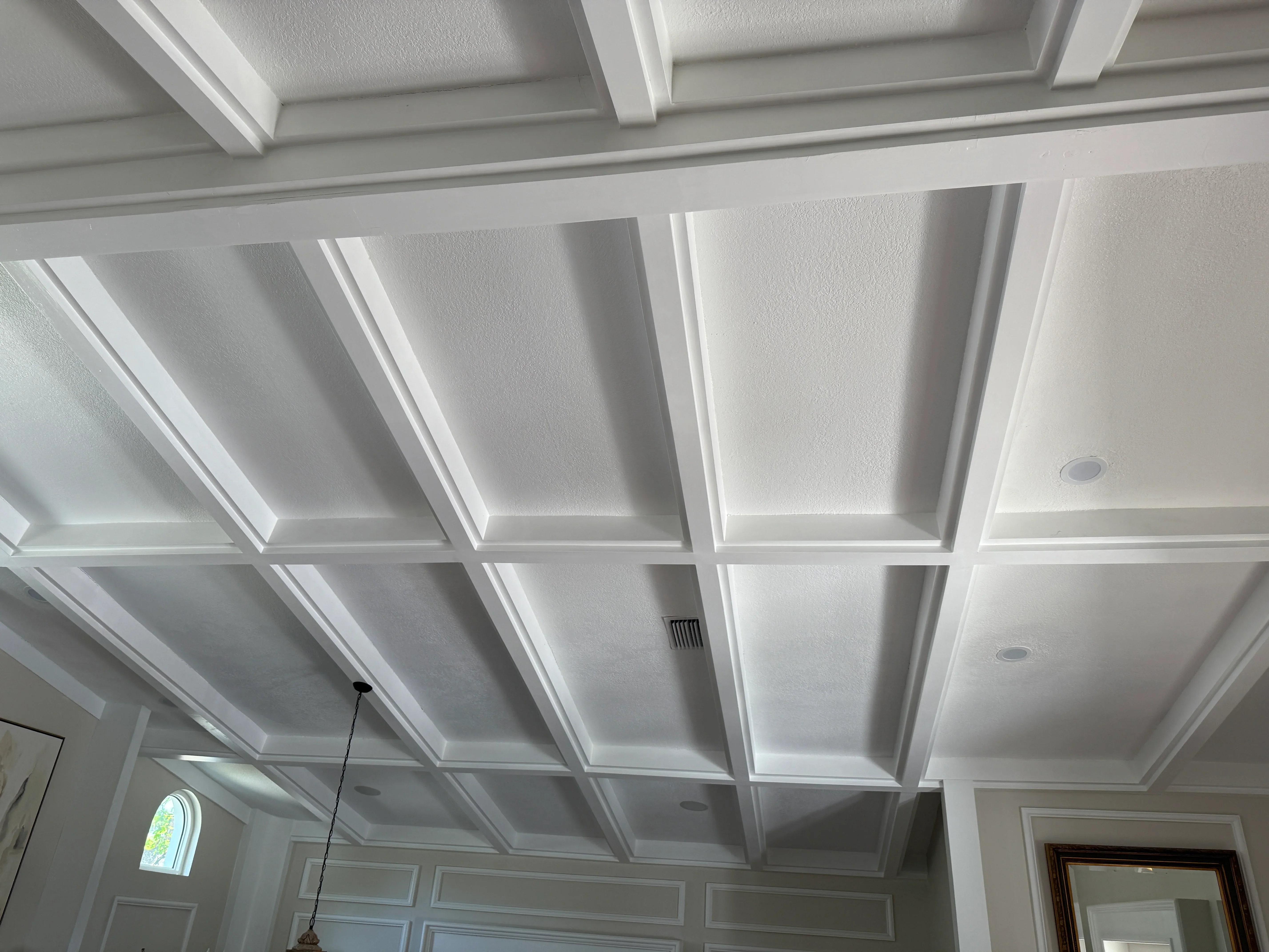 White coffered ceiling with recessed panels, trim work, and integrated lighting fixtures