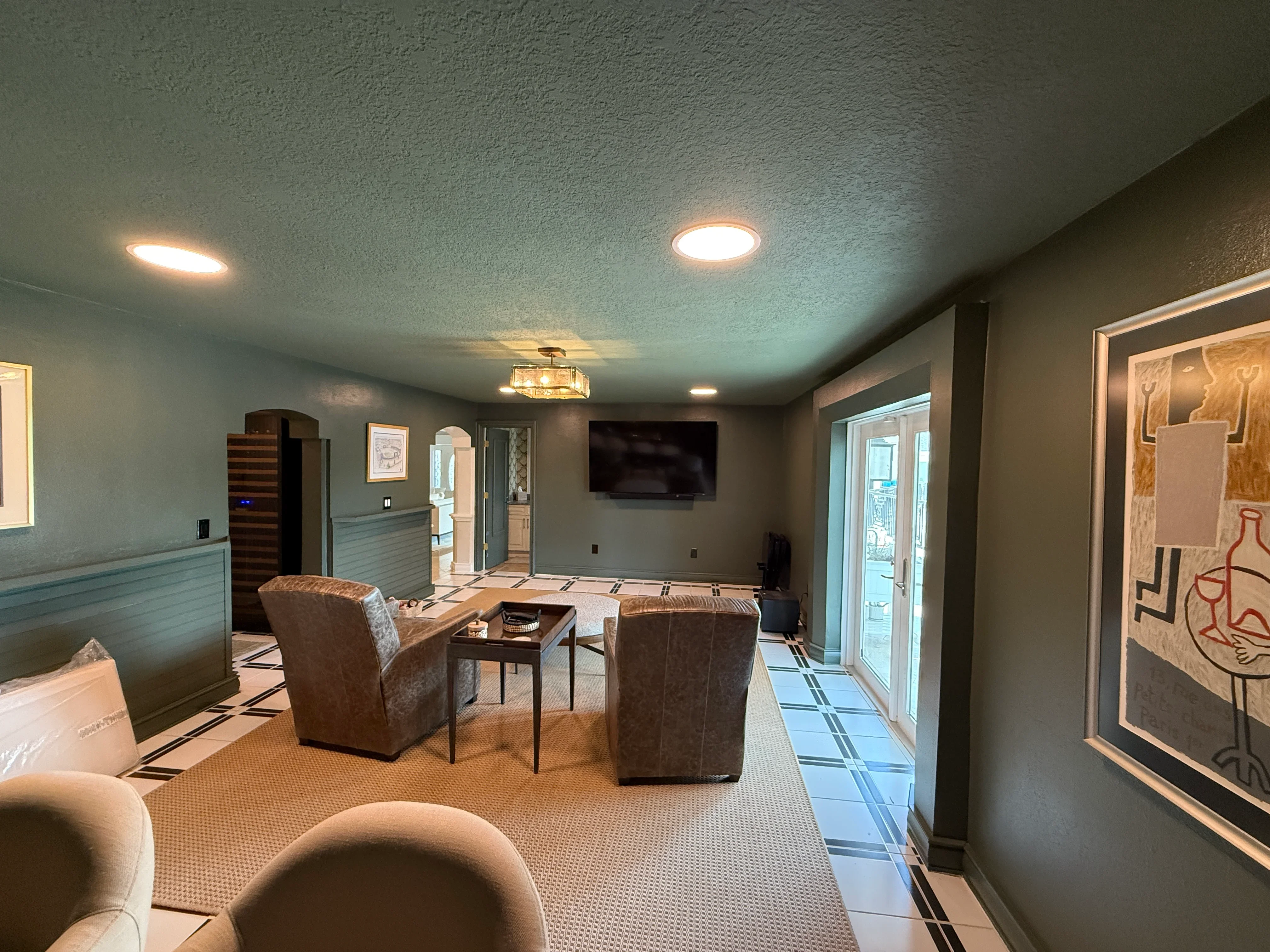 Finished basement recreation room with gray walls, recessed lighting, and comfortable seating arrangement