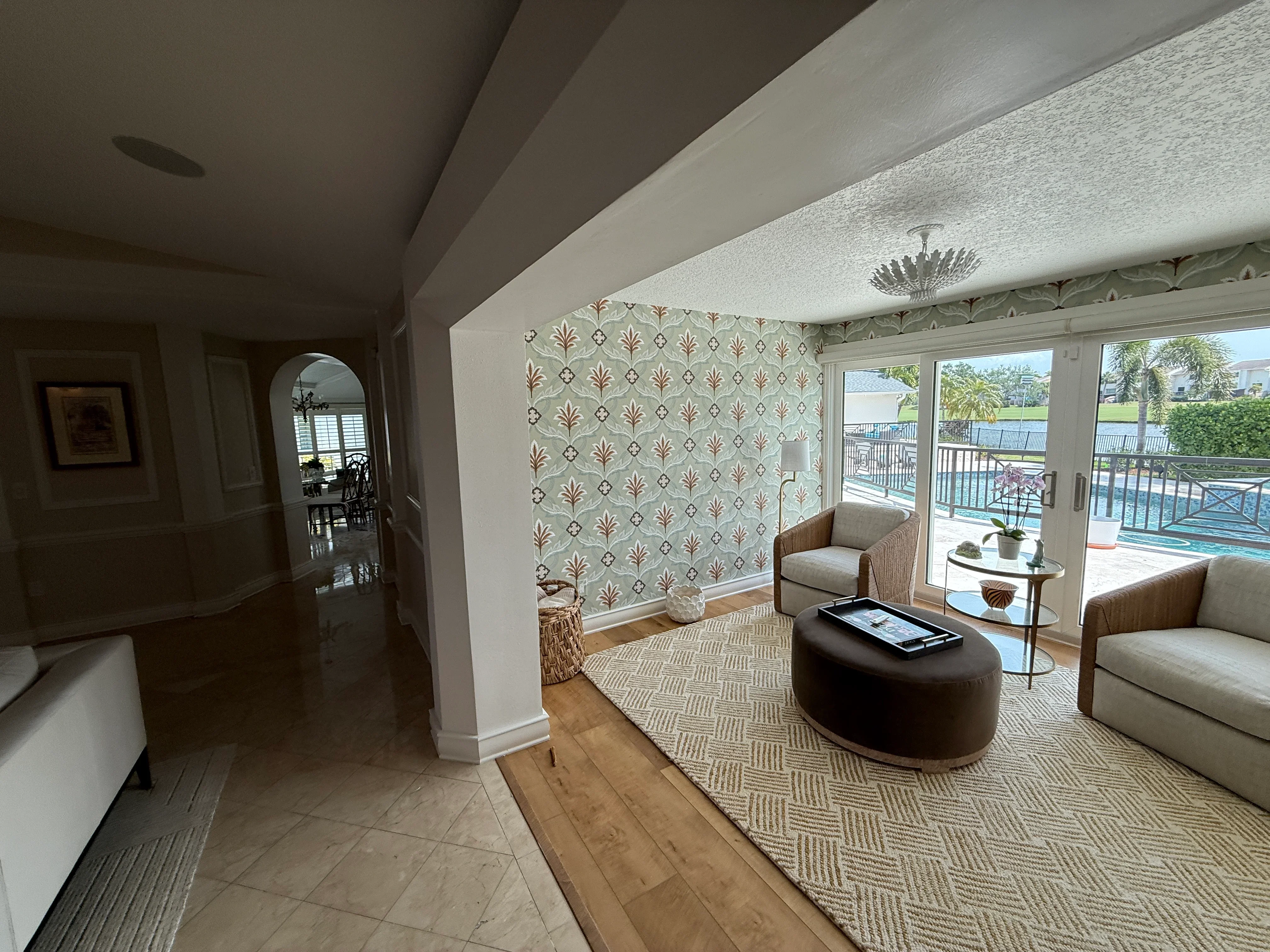 Renovated condo living room with patterned wallpaper, hardwood floors, and waterfront views